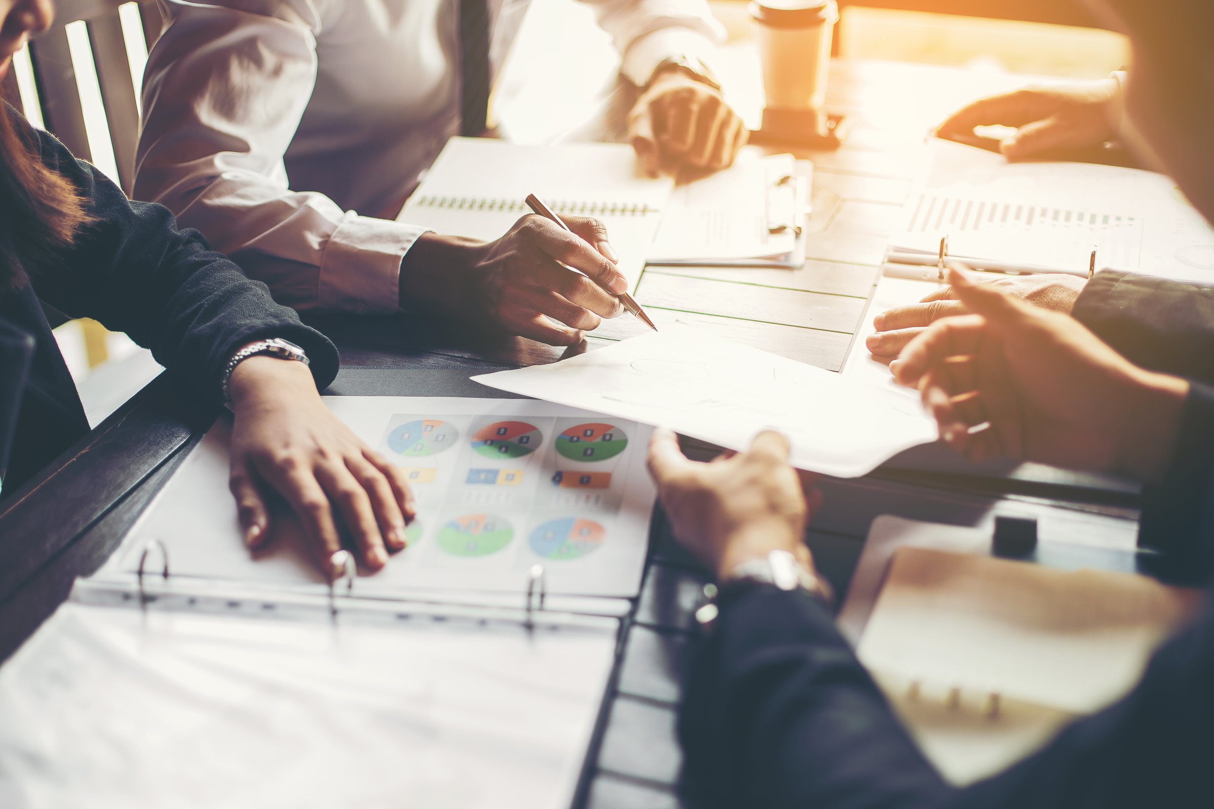 Hands reviewing financial documents at a working table