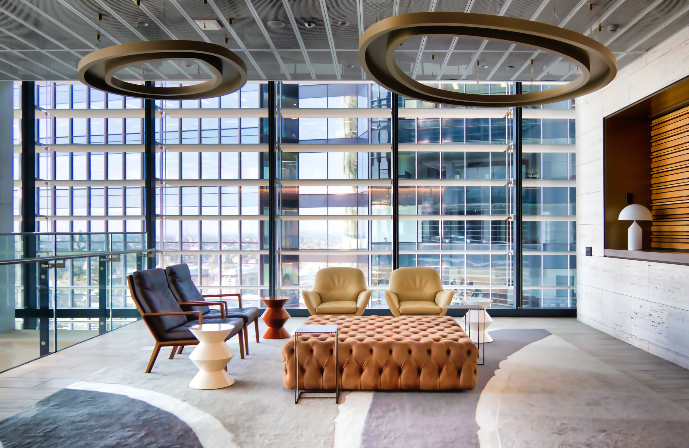 Daylight across a contemporary reception area with warm wood and leather seating